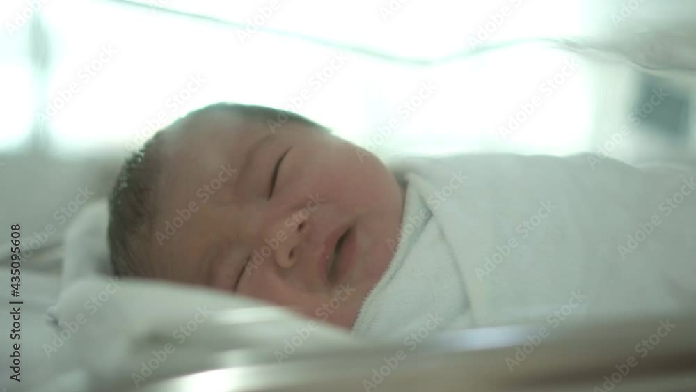 Asian Newborn baby lying on white bed in the hospital. Asian Newborn baby lying on white bed in the hospital.
