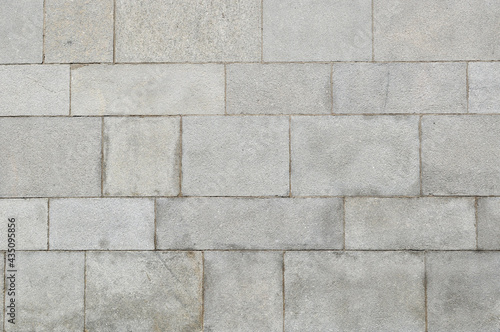 Background, texture, design. A wall of large gray stone blocks.