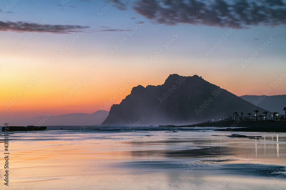 Sunrise at the famous mediterranean sea. Beautiful summer view seascape. The wet sand on the sea coast. Morning landscape. Waves with foam. Romantic relax places. Location place Antalya, Turkey.