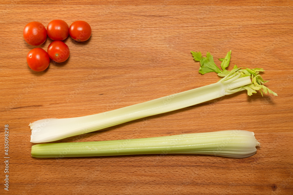 Tomatoes and lettuce with celery on a wooden table Tomatoes and lettuce with celery on a wooden table