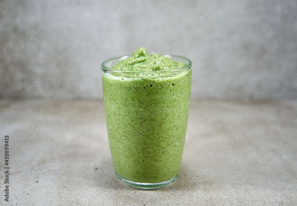 A glass full of thick green vegetable smoothie A glass full of thick green vegetable smoothie