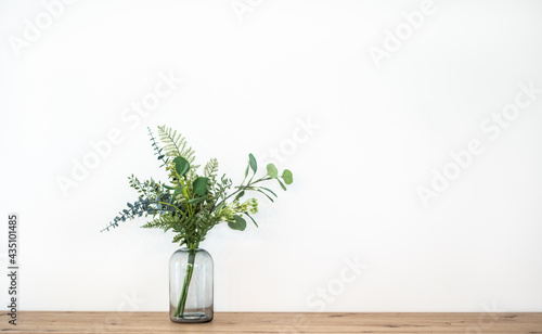 minimal home interior mock up with glas vase and green plants photo