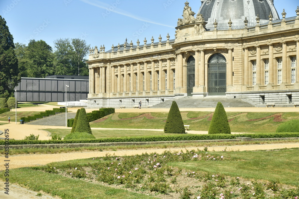Fototapeta premium Le Jardin Français avec ses allées ,pelouses et haies parfois en cone devant l'imposant Musée National de l'Afrique Centrale au parc de Tervuren à l'est de Bruxelles 