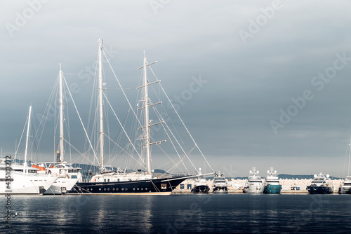 Large sailing yacht among the smaller yachts at the marina © kirill_makarov