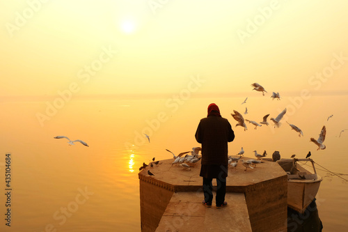 Photography 03 Feb 2021, man Feeding to birds on the ghats of varanasi, Uttar pradesh, India