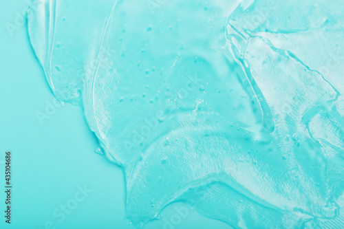 Gel with hyaluronic acid in the form of a smear of glossy texture on a cyan background.