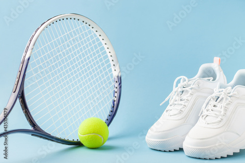 Tennis paddle rackets with ball on blue background. Summer sport activity concept. Flying © murziknata