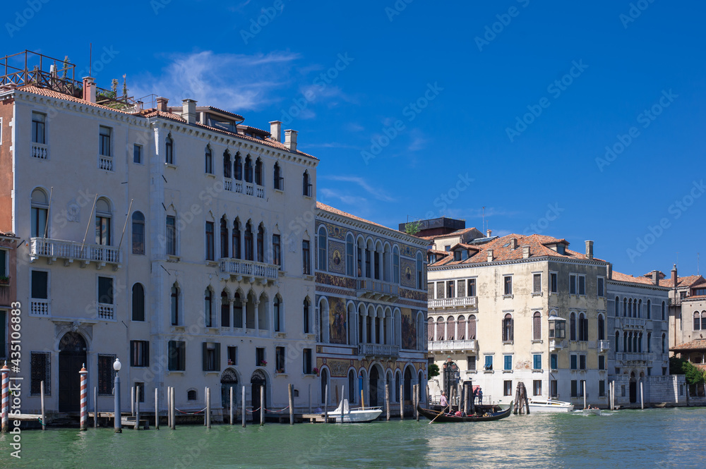 facades facing blue clean waters of busy grand canal of Venice