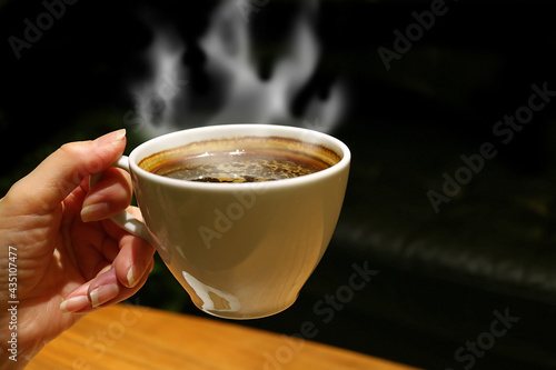 Cup of Aromatic Hot Coffee with Rising Steam in Woman's Hand