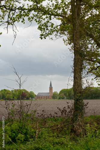 The Jacobskerk in the Dutch village Rolde, a gothic church on the edge of the village, bordering a field © Matauw