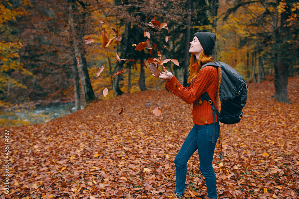 woman in a sweater hat jeans 3 law on the back and nature in the background trees forest model woman in a sweater hat jeans 3 law on the back and nature in the background trees forest model