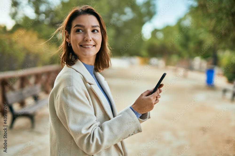Young hispanic woman smiling happy using smartphone at the park. Young hispanic woman smiling happy using smartphone at the park.