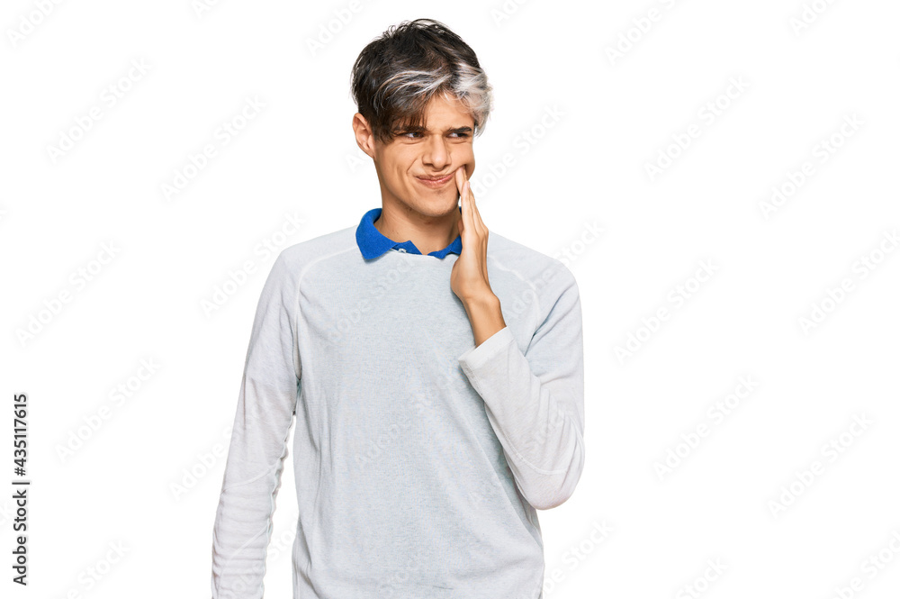 Young hispanic man wearing casual clothes touching mouth with hand with painful expression because of toothache or dental illness on teeth. dentist Young hispanic man wearing casual clothes touching mouth with hand with painful expression because of toothache or dental illness on teeth. dentist