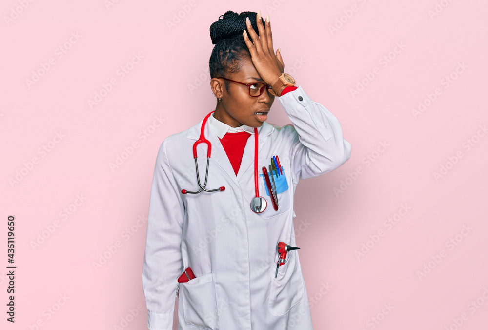 Young african american woman wearing doctor uniform and stethoscope surprised with hand on head for mistake, remember error. forgot, bad memory concept. Young african american woman wearing doctor uniform and stethoscope surprised with hand on head for mistake, remember error. forgot, bad memory concept.