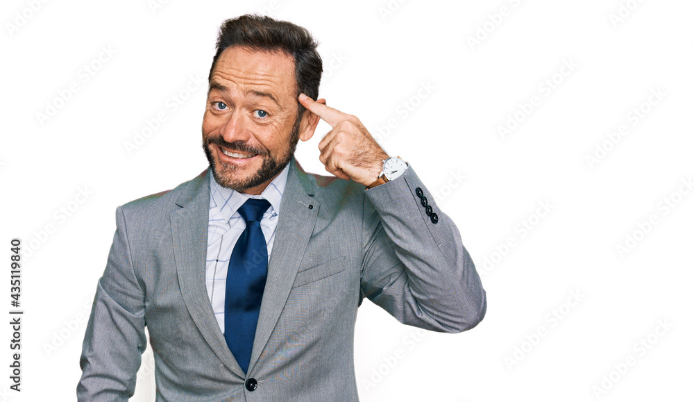 Middle age man wearing business clothes smiling pointing to head with one finger, great idea or thought, good memory Middle age man wearing business clothes smiling pointing to head with one finger, great idea or thought, good memory