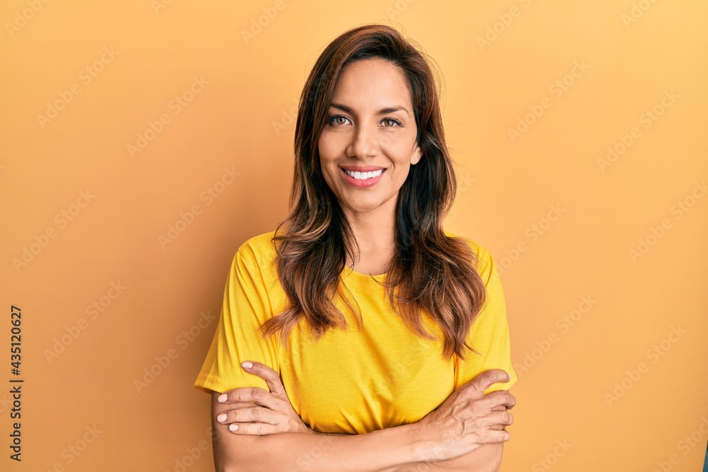 Young latin woman wearing casual clothes happy face smiling with crossed arms looking at the camera. positive person. Young latin woman wearing casual clothes happy face smiling with crossed arms looking at the camera. positive person.