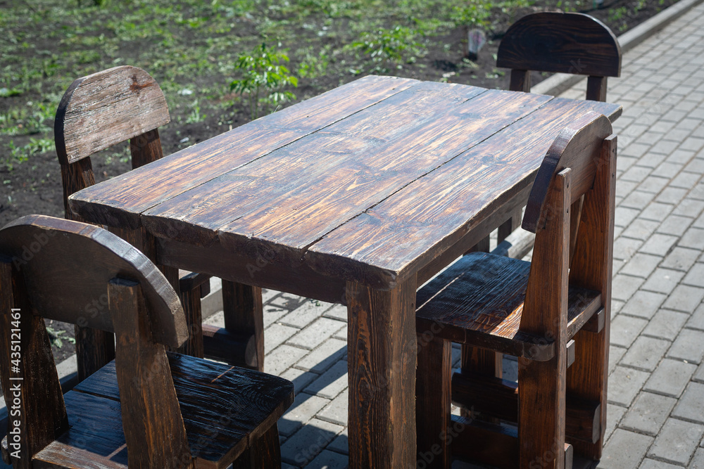 Wooden table with wooden chairs outside.