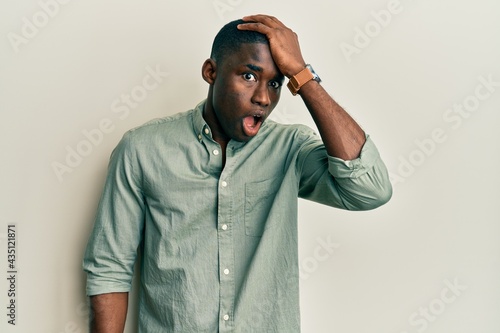 Young african american man wearing casual clothes surprised with hand on head for mistake, remember error. forgot, bad memory concept.