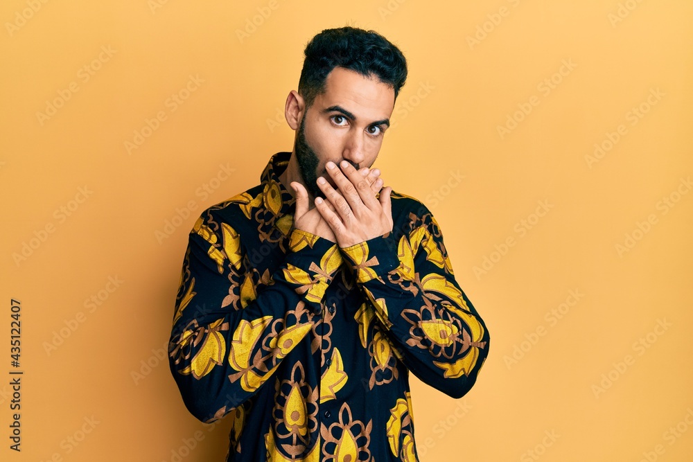 Young hispanic man wearing casual shirt shocked covering mouth with hands for mistake. secret concept. Young hispanic man wearing casual shirt shocked covering mouth with hands for mistake. secret concept.