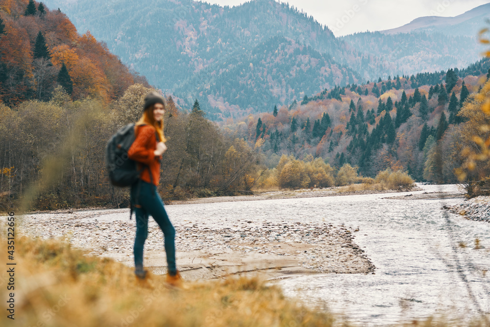 woman travels in autumn in the mountains near the river landscape model in full growth