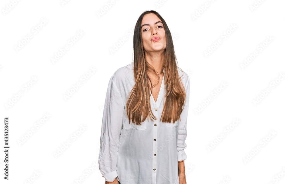 Young beautiful woman wearing casual clothes looking at the camera blowing a kiss on air being lovely and sexy. love expression. Young beautiful woman wearing casual clothes looking at the camera blowing a kiss on air being lovely and sexy. love expression.