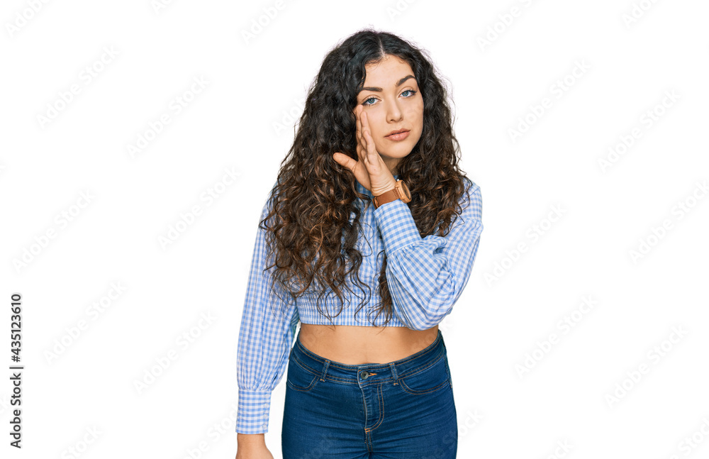 Young hispanic girl wearing casual clothes hand on mouth telling secret rumor, whispering malicious talk conversation Young hispanic girl wearing casual clothes hand on mouth telling secret rumor, whispering malicious talk conversation
