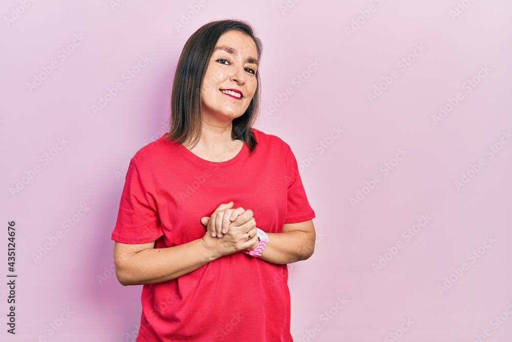 Middle age hispanic woman wearing casual clothes with hands together and crossed fingers smiling relaxed and cheerful. success and optimistic Middle age hispanic woman wearing casual clothes with hands together and crossed fingers smiling relaxed and cheerful. success and optimistic