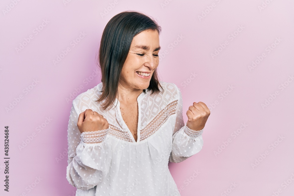 Middle age hispanic woman wearing casual clothes excited for success with arms raised and eyes closed celebrating victory smiling. winner concept. Middle age hispanic woman wearing casual clothes excited for success with arms raised and eyes closed celebrating victory smiling. winner concept.