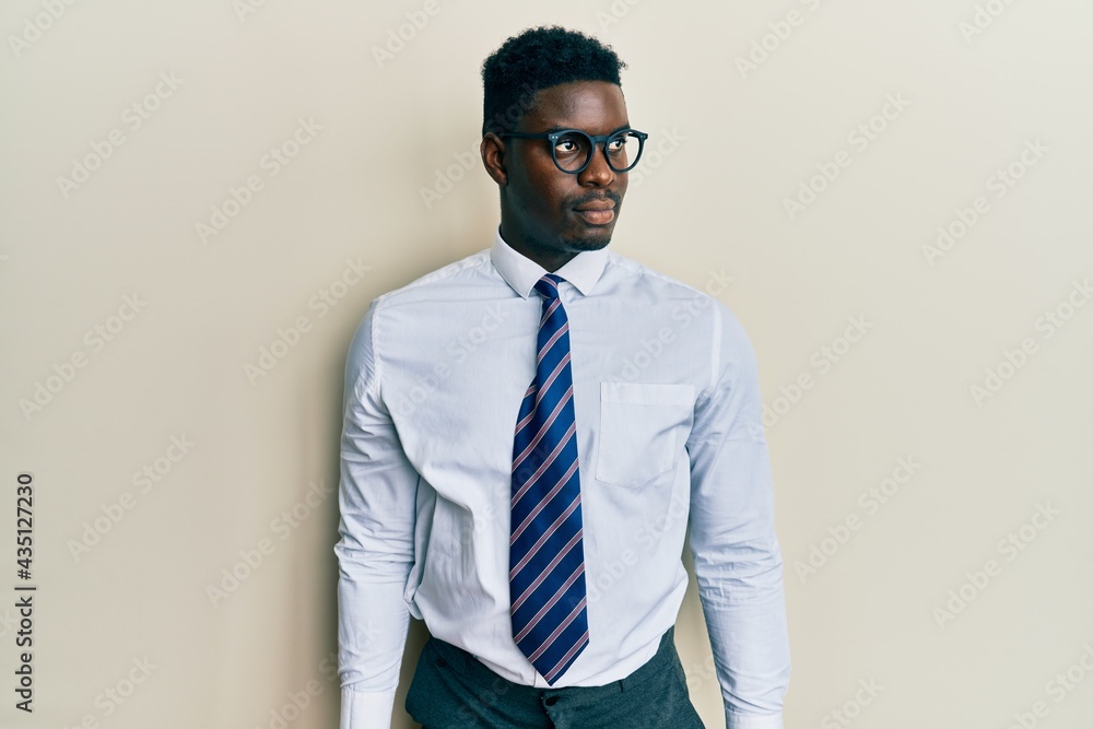 Handsome black man wearing glasses business shirt and tie smiling looking to the side and staring away thinking. Handsome black man wearing glasses business shirt and tie smiling looking to the side and staring away thinking.