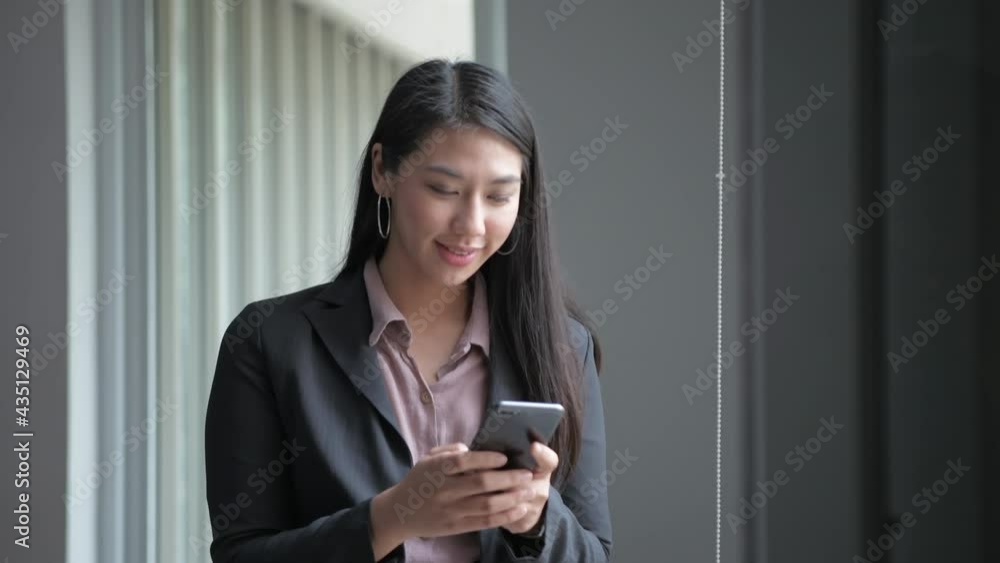 Business concept of 4k Resolution. Asian girls are happily using the phone in the office. Business concept of 4k Resolution. Asian girls are happily using the phone in the office.