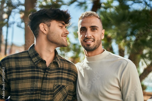 Young gay couple smiling happy and hugging at the city.