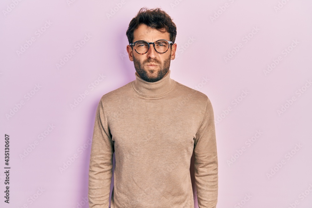 Obraz premium Handsome man with beard wearing turtleneck sweater and glasses skeptic and nervous, frowning upset because of problem. negative person.