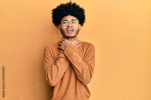 Young african american man with afro hair wearing casual winter sweater shouting and suffocate because painful strangle. health problem. asphyxiate and suicide concept. © Krakenimages.com