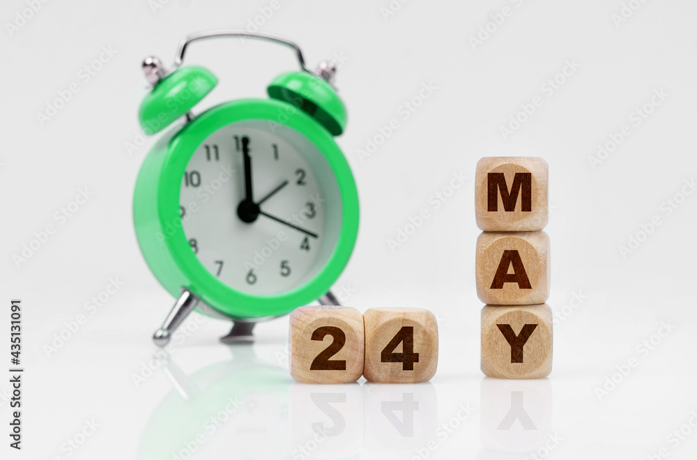 On a white background there is an alarm clock and a calendar with the inscription - MAY 24 On a white background there is an alarm clock and a calendar with the inscription - MAY 24