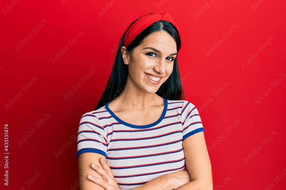 Young hispanic woman wearing casual clothes happy face smiling with crossed arms looking at the camera. positive person. Young hispanic woman wearing casual clothes happy face smiling with crossed arms looking at the camera. positive person.