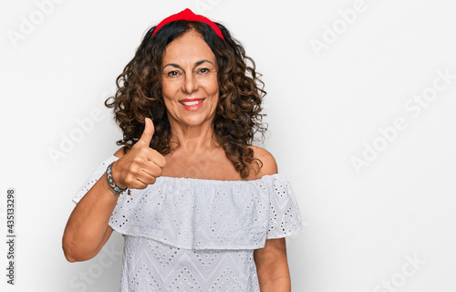 Fotografie Middle age hispanic woman wearing casual clothes smiling happy and positive, thu