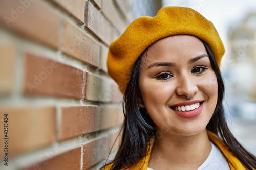 Young latin girl smiling happy standing at the city.