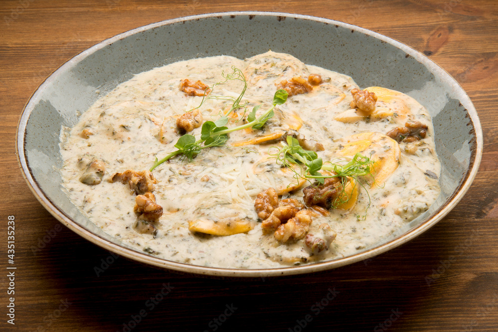 Baked potato with a mushroom cream sauce, mozzarella, and fresh basil leaves. Baked potato with a mushroom cream sauce, mozzarella, and fresh basil leaves.