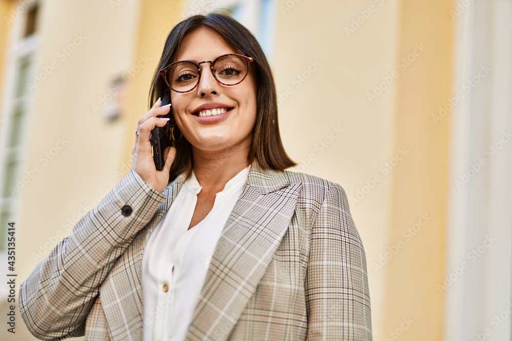 Young hispanic businesswoman smiling happy talking by the smartphone at the city. Young hispanic businesswoman smiling happy talking by the smartphone at the city.