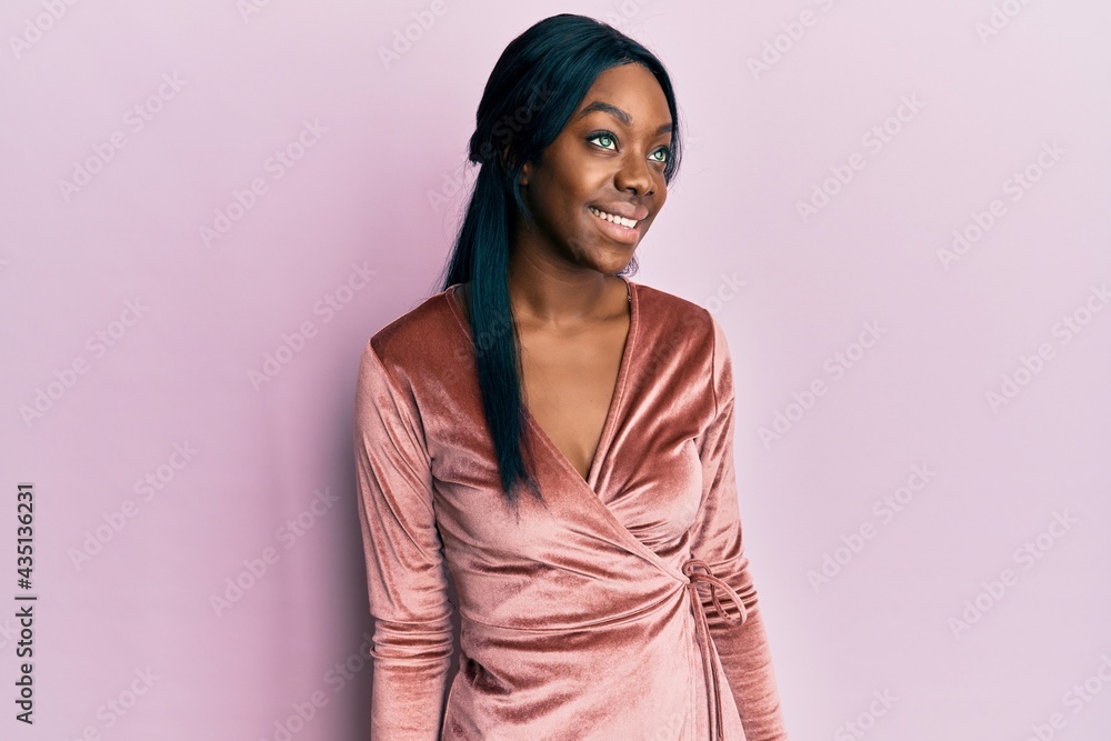 Young african american woman wearing sexy party dress looking to side, relax profile pose with natural face and confident smile. Young african american woman wearing sexy party dress looking to side, relax profile pose with natural face and confident smile.