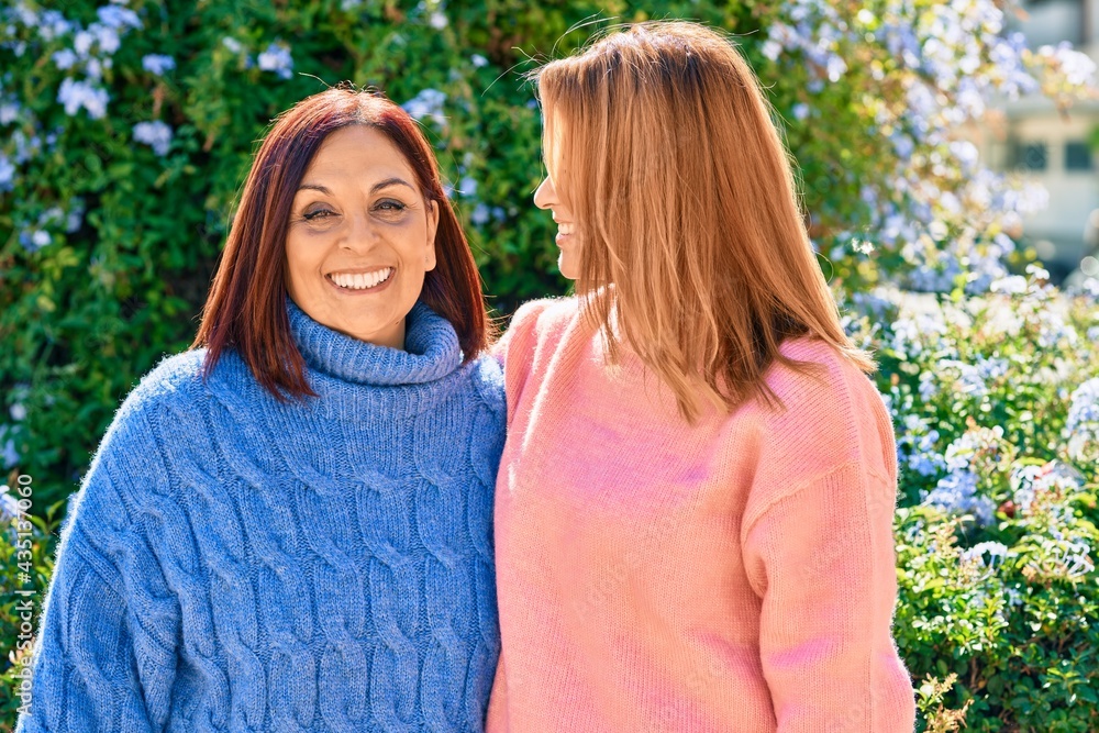 Hispanic mother and daughter smiling happy and hugging at the park. Hispanic mother and daughter smiling happy and hugging at the park.