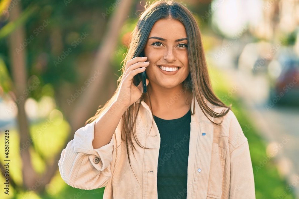 Young hispanic girl smiling happy talking on the smartphone at the park. Young hispanic girl smiling happy talking on the smartphone at the park.