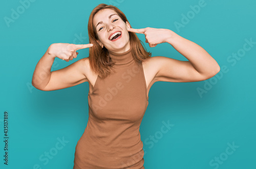 Young caucasian woman wearing casual clothes smiling cheerful showing and pointing with fingers teeth and mouth. dental health concept.