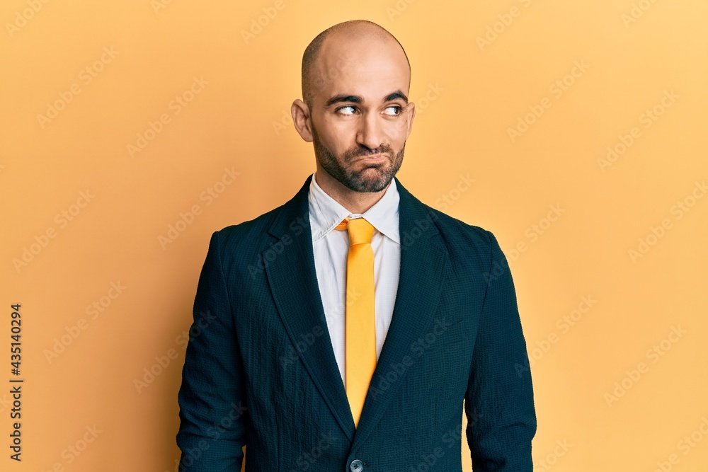 Young hispanic man wearing business suit and tie smiling looking to the side and staring away thinking. Young hispanic man wearing business suit and tie smiling looking to the side and staring away thinking.