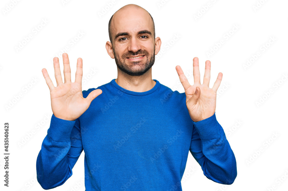 Naklejka premium Young hispanic man wearing casual clothes showing and pointing up with fingers number nine while smiling confident and happy.