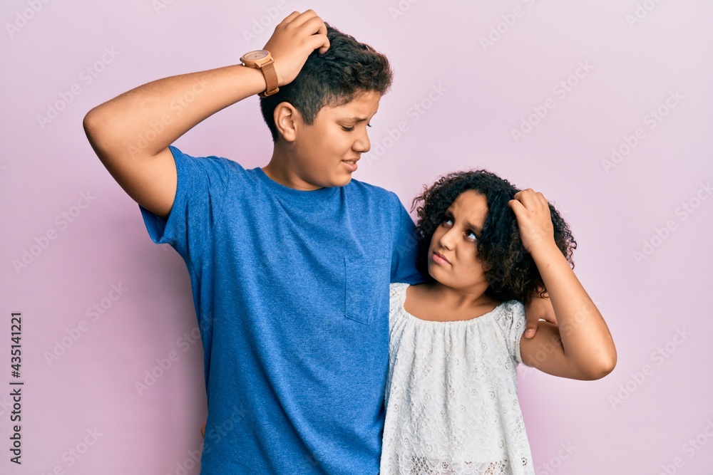 Young hispanic family of brother and sister wearing casual clothes together confuse and wondering about question. uncertain with doubt, thinking with hand on head. pensive concept. Young hispanic family of brother and sister wearing casual clothes together confuse and wondering about question. uncertain with doubt, thinking with hand on head. pensive concept.