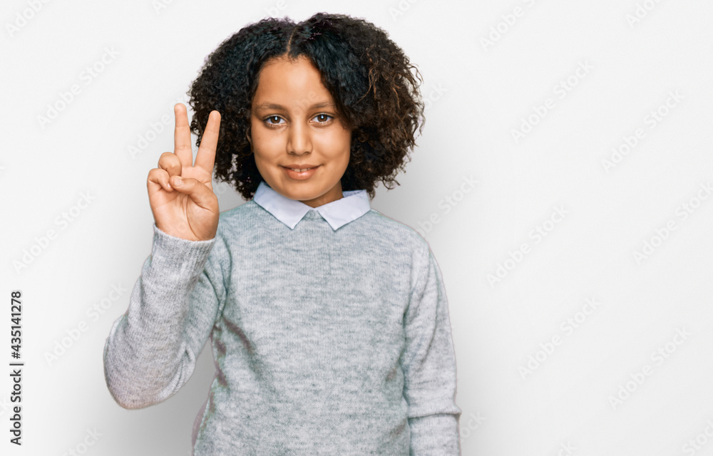 Young little girl with afro hair wearing casual clothes showing and pointing up with fingers number two while smiling confident and happy. Young little girl with afro hair wearing casual clothes showing and pointing up with fingers number two while smiling confident and happy.