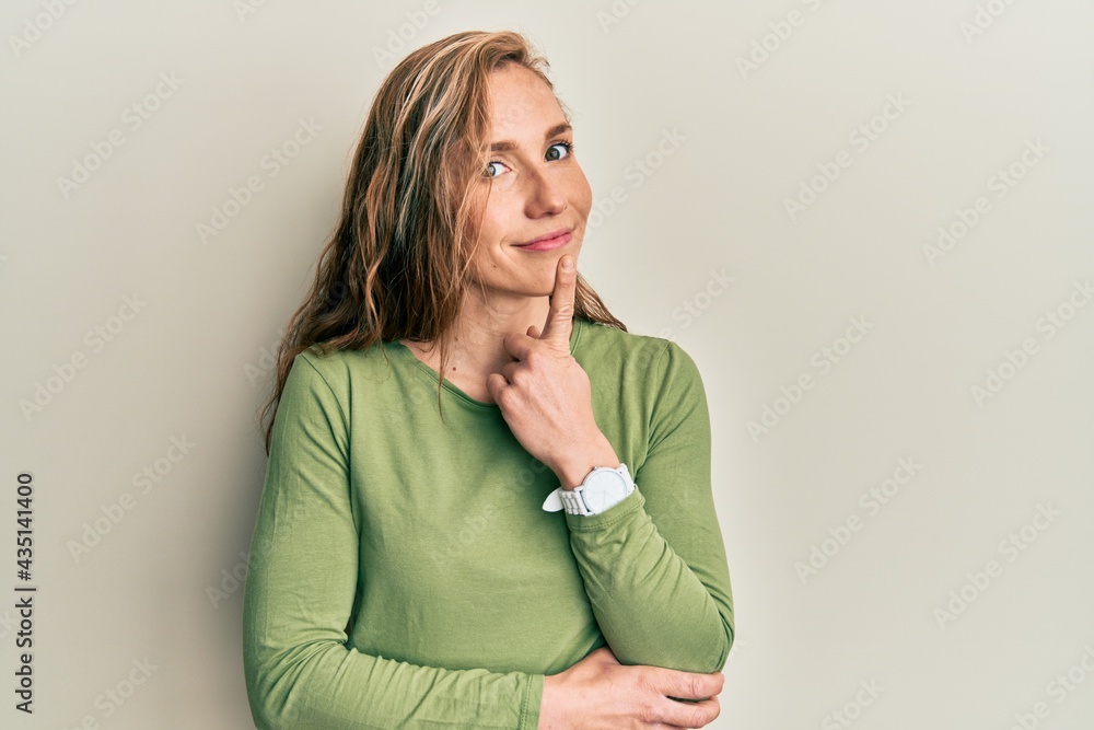 Young blonde woman wearing casual clothes smiling looking confident at the camera with crossed arms and hand on chin. thinking positive. Young blonde woman wearing casual clothes smiling looking confident at the camera with crossed arms and hand on chin. thinking positive.