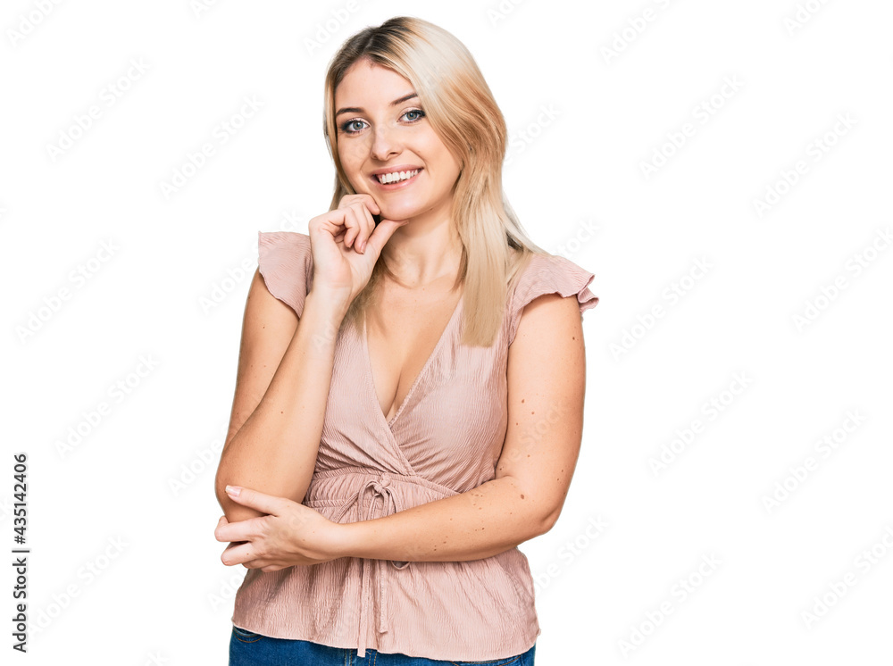 Young caucasian woman wearing casual clothes looking confident at the camera with smile with crossed arms and hand raised on chin. thinking positive. Young caucasian woman wearing casual clothes looking confident at the camera with smile with crossed arms and hand raised on chin. thinking positive.