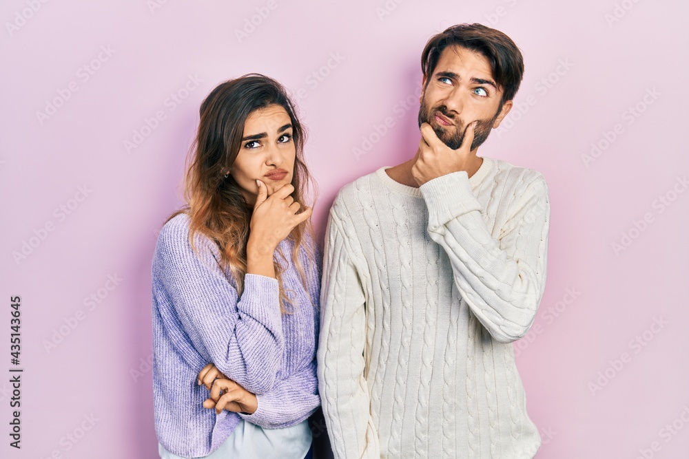 Young hispanic couple wearing casual clothes thinking worried about a question, concerned and nervous with hand on chin Young hispanic couple wearing casual clothes thinking worried about a question, concerned and nervous with hand on chin